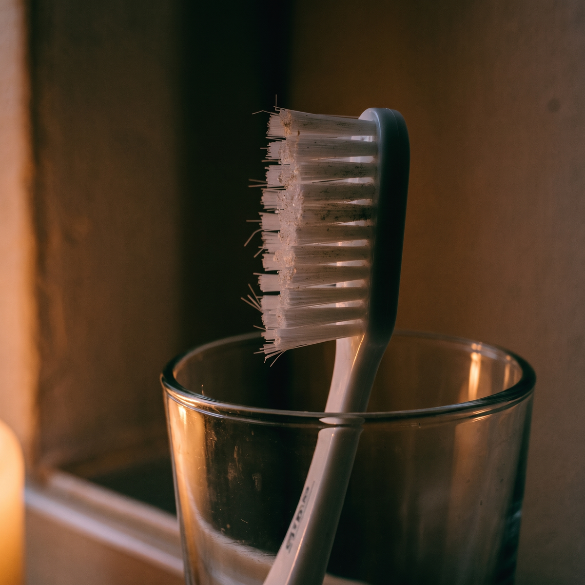 Slidt plastiktandbørste i et glas
